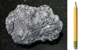 Lump of mineral graphite and a pencil - one of the most common uses of this allotrope