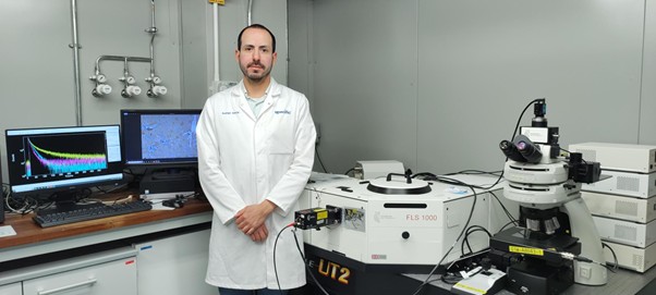 Dr. Rodrigo García standing in a lab infront of the FLS1000 from Edinburgh Instruments.